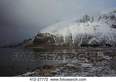 Snow covered mountains above cold lake, Norway View Large Photo Image Stock Image - Snow covered mountains above cold lake, Norway. Fotosearch