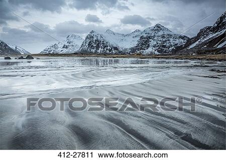 Snow covered mountains behind cold beach, Skagsanden Beach, Lofoten Islands, Norway View Large Photo Image Stock Image - Snow covered mountains behind cold beach, Skagsanden Beach, Lofoten Islands, Norway. Fotosearch