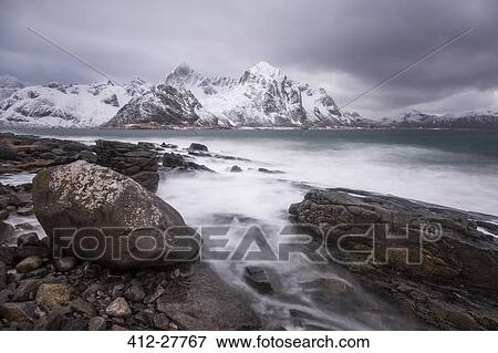 Snow covered mountains behind craggy cold lake, Haukland Lofoten Islands, Norway View Large Photo Image Stock Photo - Snow covered mountains behind craggy cold lake, Haukland Lofoten Islands, Norway. Fotosearch