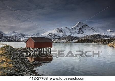 Snow covered mountains behind fishing hut over lake, Sund, Lofoten Islands, Norway View Large Photo Image Stock Photo - Snow covered mountains behind fishing hut over lake, Sund, Lofoten Islands, Norway. Fotosearch