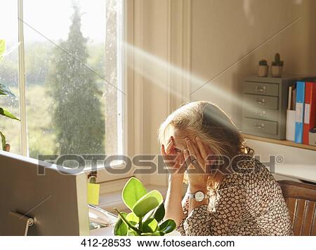 Stressed woman using computer in sunny home office View Large Photo Image Stock Image - Stressed woman using computer in sunny home office. Fotosearch