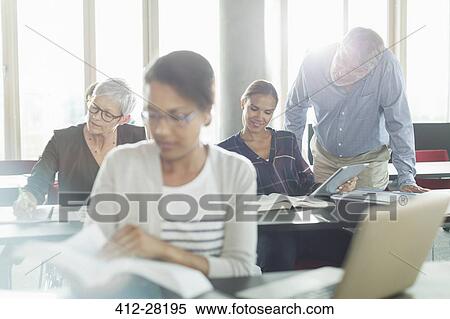 Stock Photography - Students studying in adult education classroom. Fotosearch