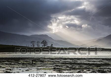 Sunbeams in stormy sky over lake, Scotland View Large Photo Image Stock Photo - Sunbeams in stormy sky over lake, Scotland. Fotosearch