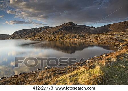 Stock Image - Sunny tranquil view of hills and bay, Scotland. Fotosearch