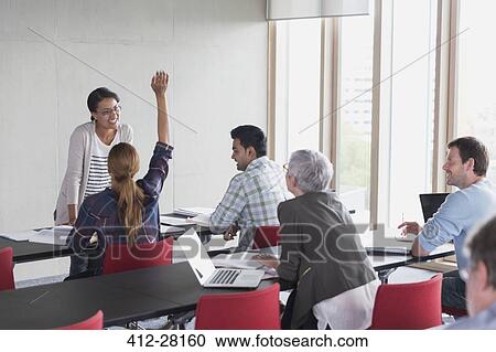 Stock Image - Teacher and students in adult education classroom. Fotosearch