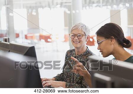 Stock Photo - Women working at computers in adult education classroom. Fotosearch