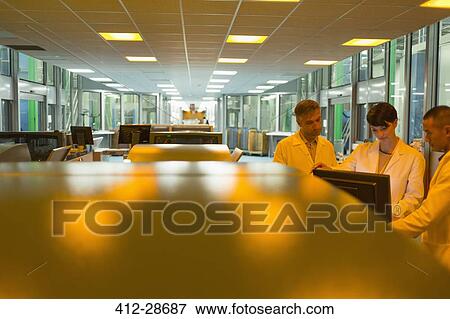 Workers at computer near printers in factory View Large Photo Image Stock Photo - Workers at computer near printers in factory. Fotosearch
