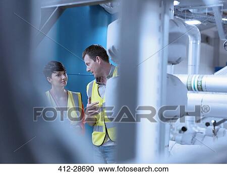 Workers talking in factory View Large Photo Image Stock Image - Workers talking in factory. Fotosearch