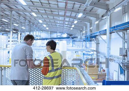 Workers with digital tablet on platform above factory View Large Photo Image Stock Photo - Workers with digital tablet on platform above factory. Fotosearch