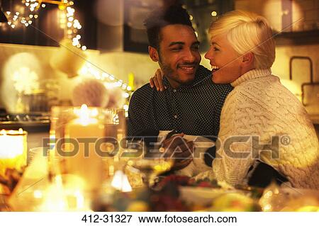 Affectionate couple with dog at candlelight Christmas table View Large Photo Image Stock Photo - Affectionate couple with dog at candlelight Christmas table. Fotosearch