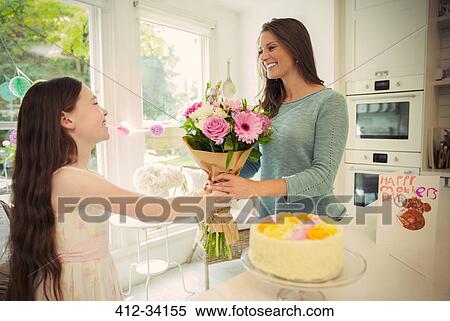 Affectionate daughter giving flower bouquet to mother on Mothers Day View Large Photo Image Stock Photography - Affectionate daughter giving flower bouquet to mother on Mothers Day. Fotosearch