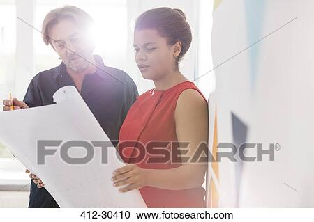 Architects discussing blueprints in office View Large Photo Image Stock Image - Architects discussing blueprints in office. Fotosearch