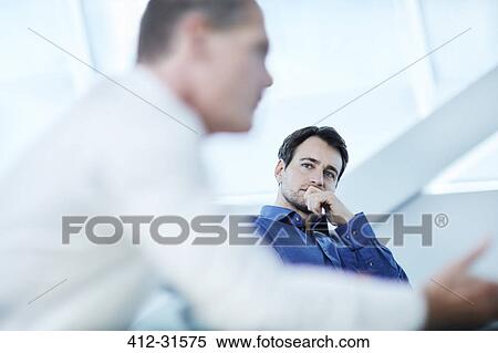 Attentive businessman listening to colleague in meeting View Large Photo Image Stock Photography - Attentive businessman listening to colleague in meeting. Fotosearch