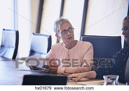 Stock Photo - Attentive businesswoman listening in conference room meeting. Fotosearch