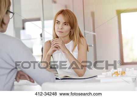 Attentive businesswoman listening to colleague in meeting View Large Photo Image Stock Photo - Attentive businesswoman listening to colleague in meeting. Fotosearch