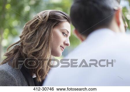 Stock Photograph - Attentive businesswoman listening to businessman. Fotosearch