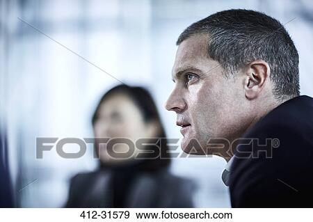 Stock Photo - Attentive serious businessman listening in meeting. Fotosearch