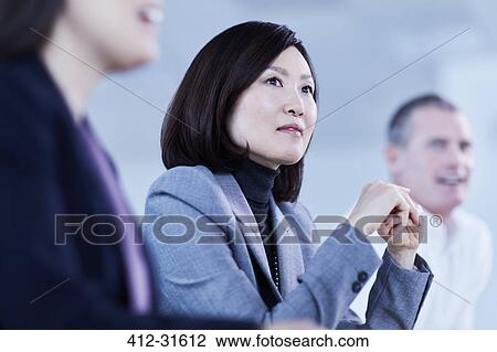 Stock Image - Attentive serious businesswoman listening in meeting. Fotosearch