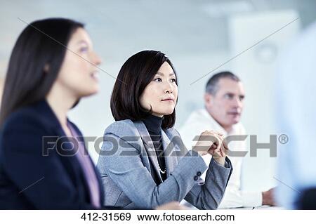 Stock Photo - Attentive serious businesswoman listening in meeting. Fotosearch