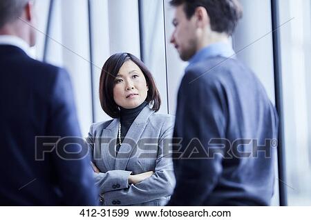 Stock Photo - Attentive serious businesswoman listening to businessman. Fotosearch