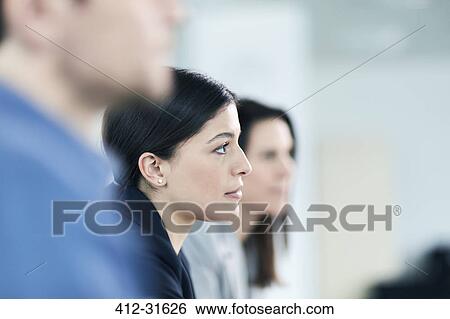 Stock Photograph - Attentive serious businesswoman listening in meeting. Fotosearch