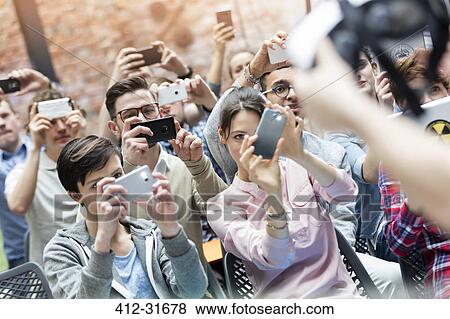 Stock Photo - Audience using camera phones at technology conference. Fotosearch