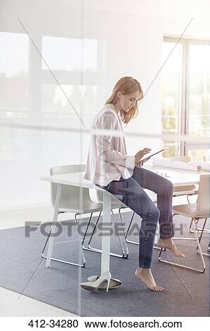 Barefoot businesswoman using digital tablet in conference room View Large Photo Image Stock Image - Barefoot businesswoman using digital tablet in conference room. Fotosearch