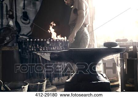 Blacksmith at fire behind anvil in forge View Large Photo Image Stock Image - Blacksmith at fire behind anvil in forge. Fotosearch