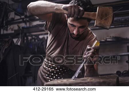 Blacksmith chiseling wood in forge View Large Photo Image Stock Photography - Blacksmith chiseling wood in forge. Fotosearch