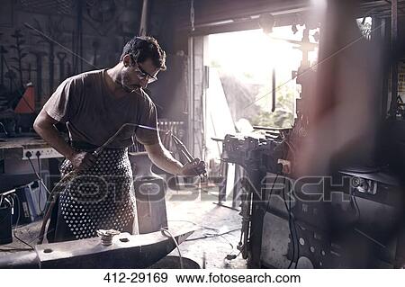 Blacksmith using blow torch in forge View Large Photo Image Stock Photo - Blacksmith using blow torch in forge. Fotosearch