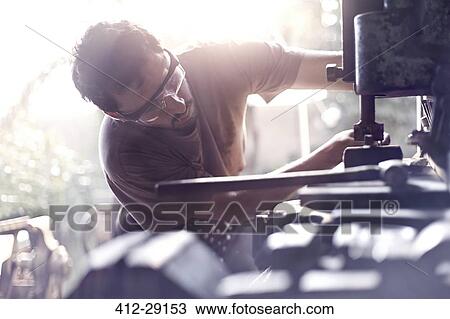 Stock Image - Blacksmith using vise grip in forge. Fotosearch