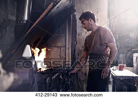 Blacksmith working at fire in forge View Large Photo Image Stock Image - Blacksmith working at fire in forge. Fotosearch