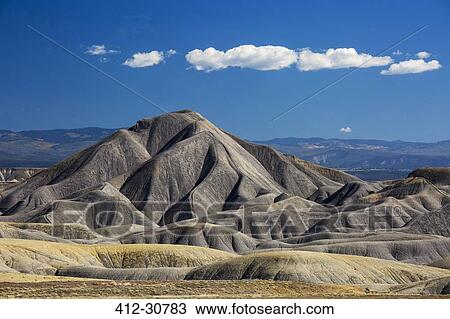 Stock Image - Blue sky and clouds over Badlands, Colorado, United States. Fotosearch