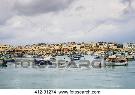 Picture - Boats mooring outside waterfront town, Marsaxlokk, Malta. Fotosearch