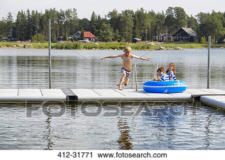 Boy jumping from dock into lake View Large Photo Image Stock Image - Boy jumping from dock into lake. Fotosearch