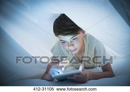 Boy using digital tablet under sheet View Large Photo Image Stock Photography - Boy using digital tablet under sheet. Fotosearch
