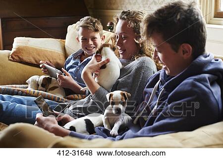 Brothers and sisters holding puppies on sofa View Large Photo Image Stock Photo - Brothers and sisters holding puppies on sofa. Fotosearch