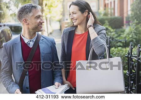 Stock Image - Business couple talking on morning sidewalk. Fotosearch