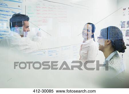 Business people brainstorming at whiteboard in office View Large Photo Image Stock Photography - Business people brainstorming at whiteboard in office. Fotosearch