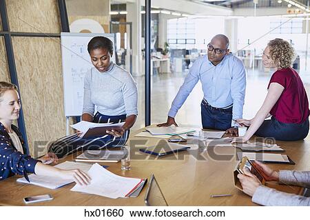 Business people discussing paperwork in conference room meeting View Large Photo Image Stock Image - Business people discussing paperwork in conference room meeting. Fotosearch