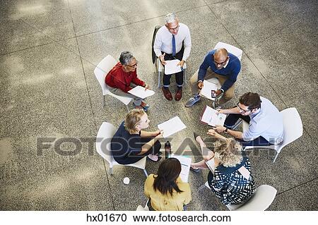 Business people discussing paperwork in meeting circle View Large Photo Image Stock Image - Business people discussing paperwork in meeting circle. Fotosearch