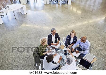 Stock Image - Business people handshaking in meeting. Fotosearch