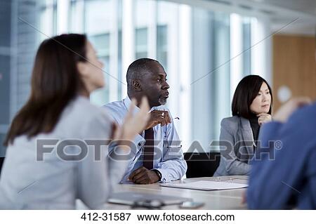 Business people listening in meeting View Large Photo Image Stock Photo - Business people listening in meeting. Fotosearch