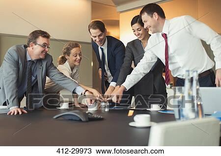 Stock Image - Business people playing team building exercise with glass in conference room. Fotosearch