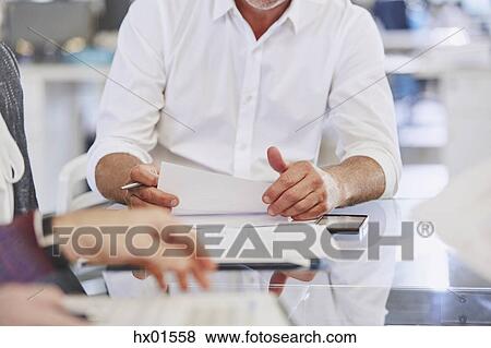 Business people reviewing paperwork in meeting View Large Photo Image Stock Photo - Business people reviewing paperwork in meeting. Fotosearch