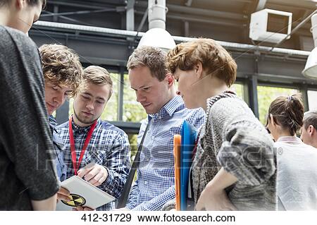 Business people using digital tablet at technology conference View Large Photo Image Stock Photo - Business people using digital tablet at technology conference. Fotosearch