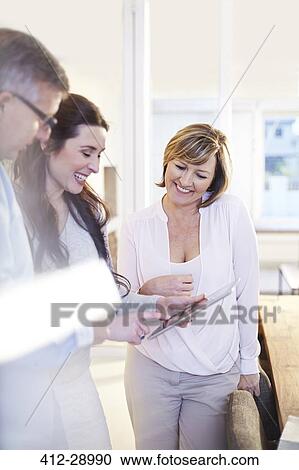 Stock Image - Business people using digital tablet. Fotosearch