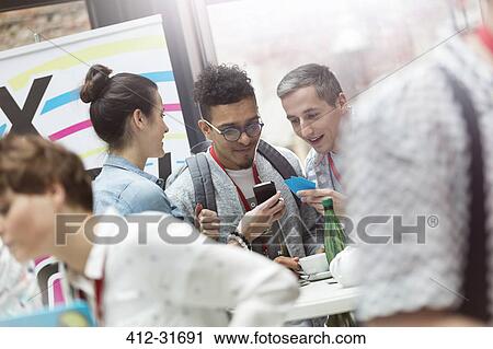 Stock Image - Business people using smart phone at technology conference. Fotosearch