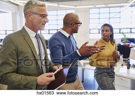 Business people walking and talking in office View Large Photo Image Stock Image - Business people walking and talking in office. Fotosearch