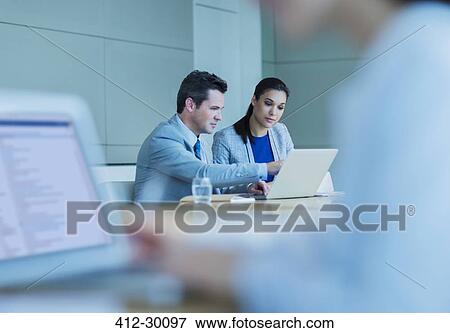 Stock Photo - Business people working at laptop in conference room. Fotosearch